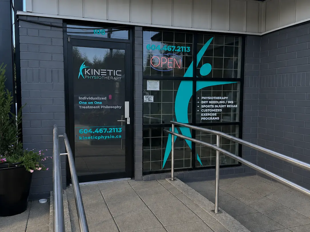 The entrance to Kinetic Therapy Clinic, with the Kinetic Physiotherapy signage on the door and a handrailed ramp leading up to it